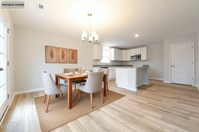 a view of a dining room with furniture a chandelier and wooden floor