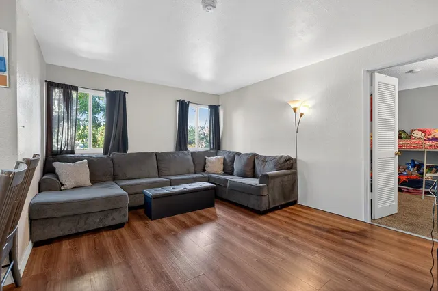 a living room with furniture and a wooden floor