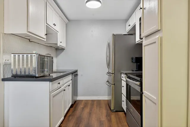 a kitchen with stainless steel appliances granite countertop a stove a refrigerator and a sink