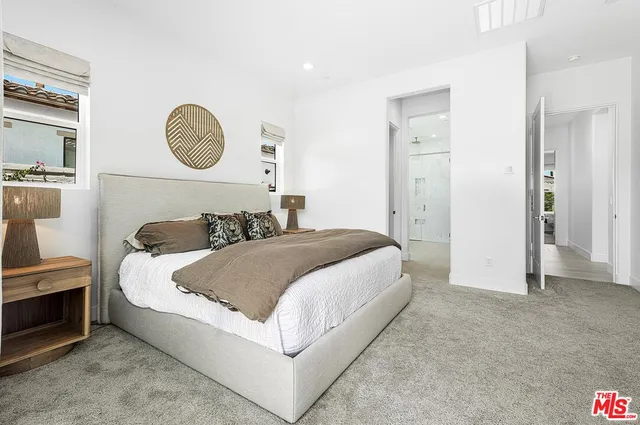 a bedroom with a bed and painting on the wall