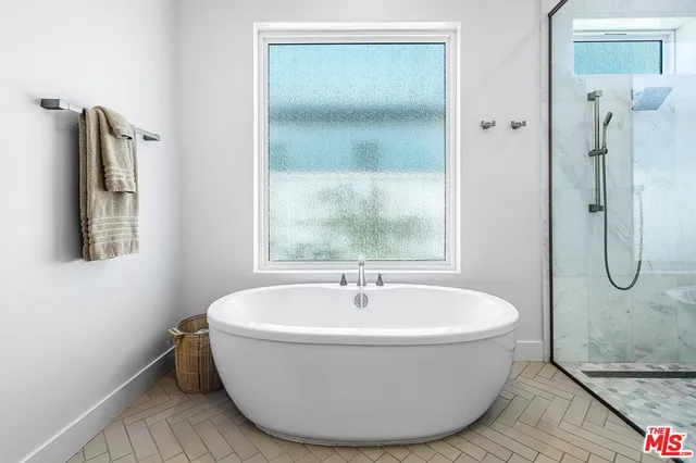 a white bath tub sitting next to a shower
