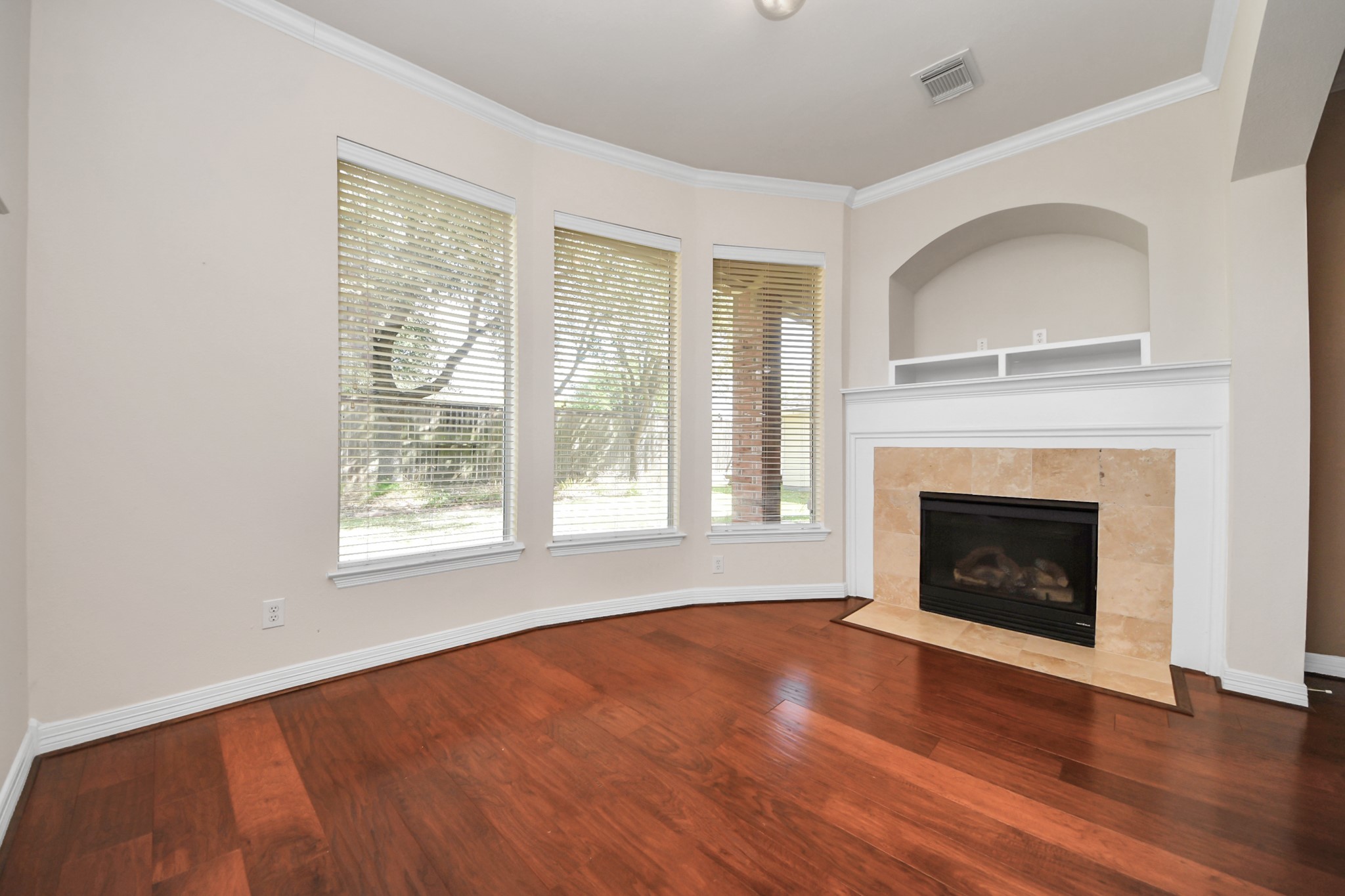 17618 Raven Canyon Lane Houston, TX 77095 - Photo 18 of 45 Bright primary bedroom space with a wall of windows and a cozy fireplace focal point.