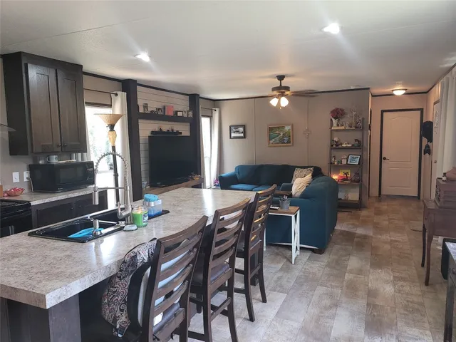 a living room with furniture a chandelier and a flat screen tv
