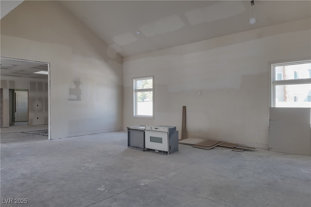 3840 South Topaz Road Las Vegas, NV 89121 - Photo 26 of 89 Empty room with unfinished concrete floors and high vaulted ceiling