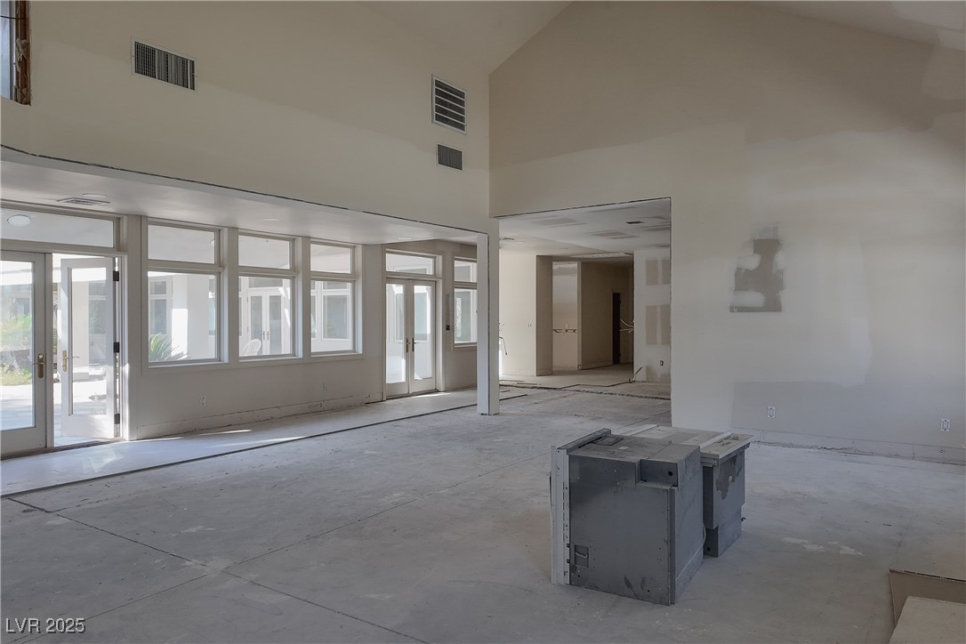 3840 South Topaz Road Las Vegas, NV 89121 - Photo 28 of 89 Unfurnished room featuring high vaulted ceiling, french doors, and unfinished concrete floors