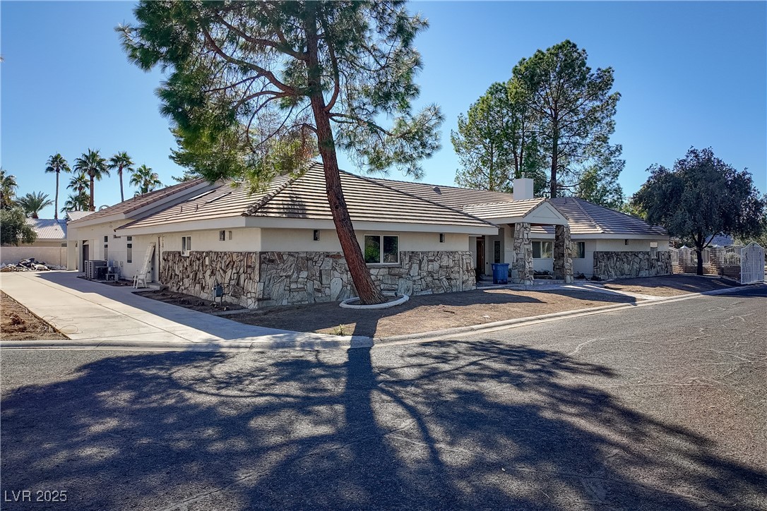 3840 South Topaz Road Las Vegas, NV 89121 - Photo 3 of 89 Ranch-style home with stone siding, stucco siding, a tile roof, and a chimney