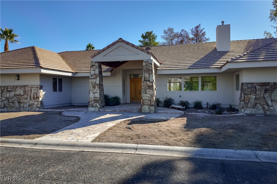 3840 South Topaz Road Las Vegas, NV 89121 - Photo 5 of 89 Single story home featuring a tile roof, stucco siding, a chimney, and stone siding