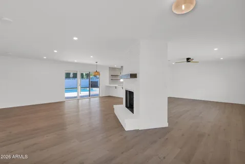 a view of an empty room with a fireplace and window