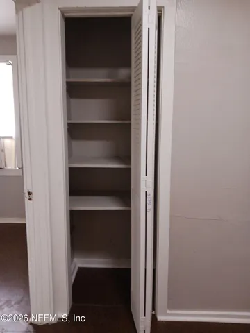 a view of walk in closet with empty racks