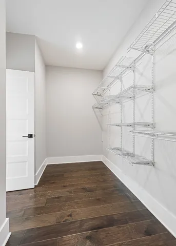 a view of an empty room with wooden floor and cabinet