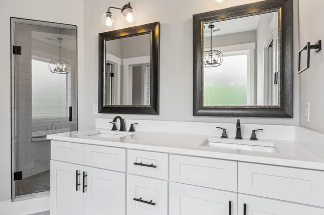 a bathroom with double vanity sinks and a mirror