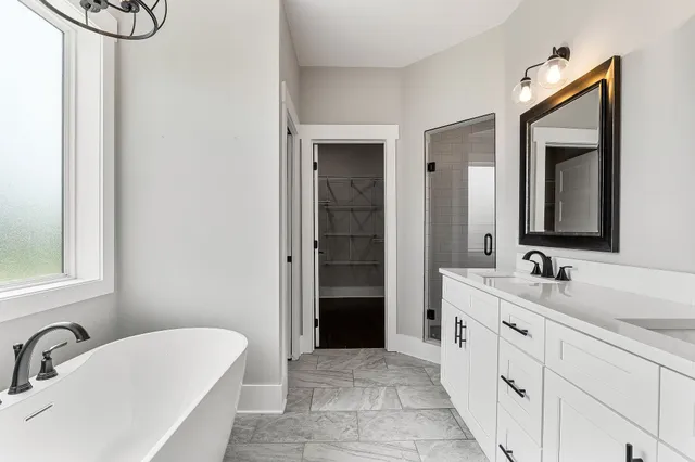 a bathroom with a double vanity sink a mirror and a bathtub