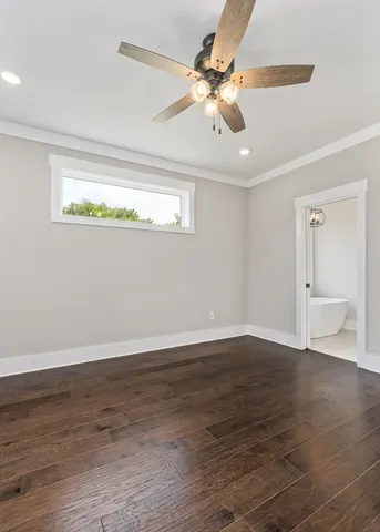 a view of a room with wooden floor fan and windows
