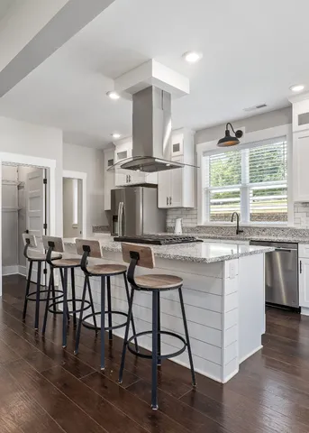 a kitchen with stainless steel appliances granite countertop a stove a sink a microwave a dining table and chairs