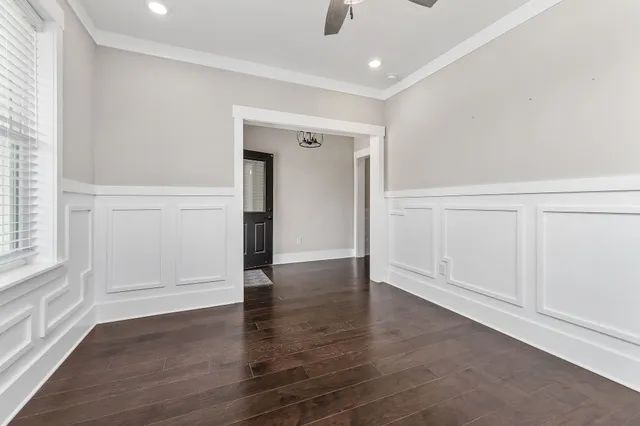 an empty room with wooden floor & closet and windows