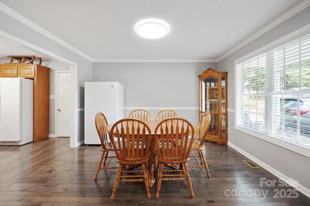 a view of a a dining room with furniture window and wooden floor