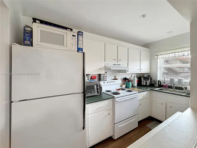 a kitchen with a refrigerator a sink and cabinets