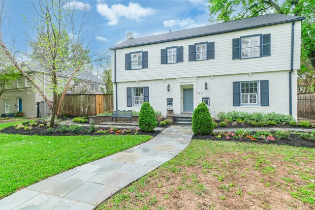a front view of a house with a yard and potted plants