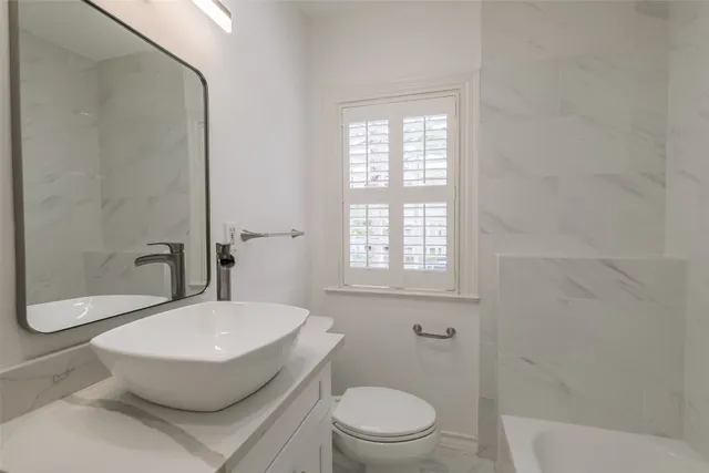 a bathroom with a toilet a sink and shower