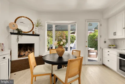 a kitchen with stainless steel appliances a stove a table and chairs