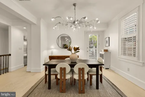 a view of a dining room with furniture a chandelier and wooden floor