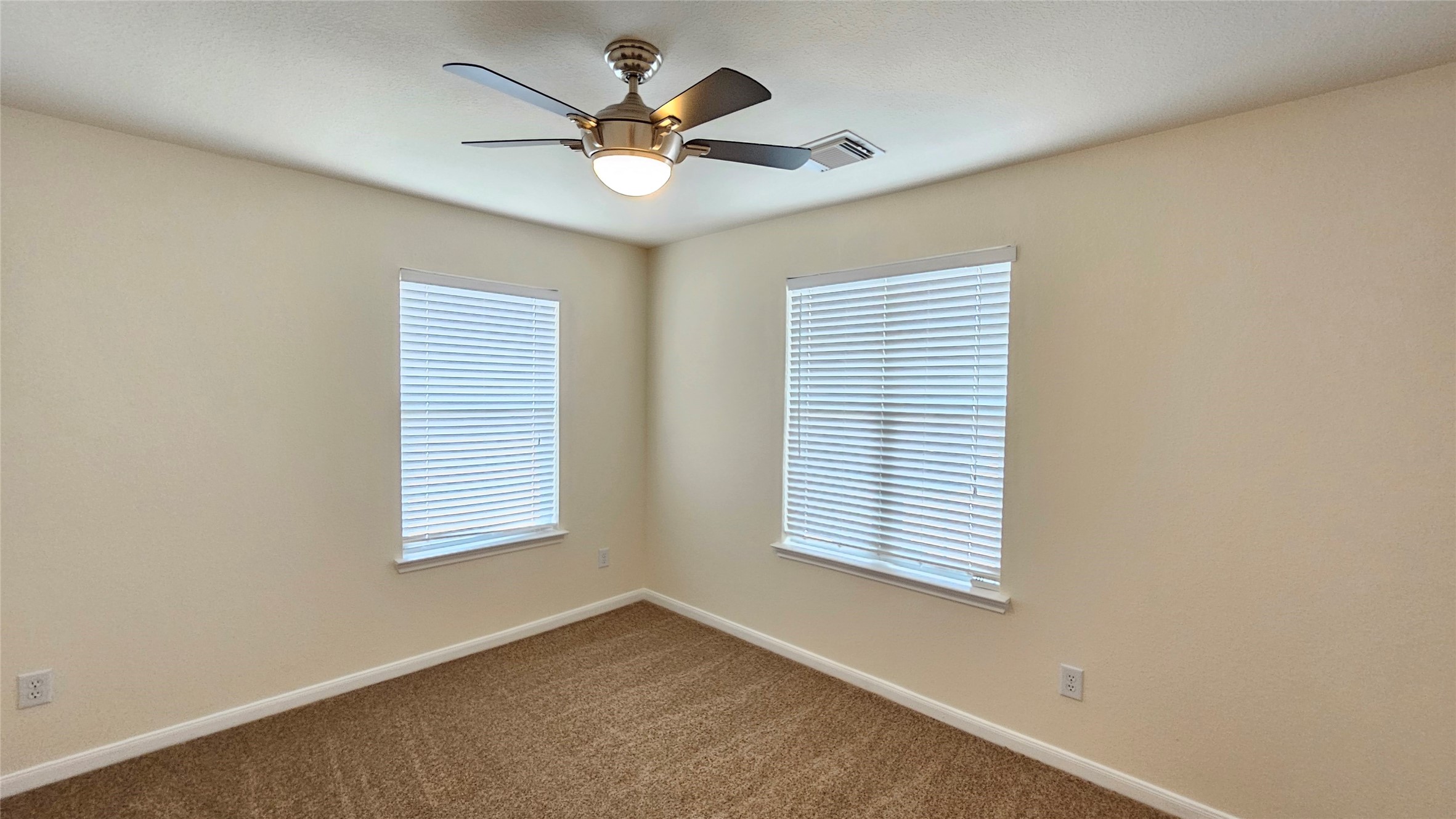 7918 Barnes Ridge Lane Houston, TX 77072 - Photo 12 of 34 This room features neutral walls, carpet flooring, and two windows with blinds, offering ample natural light. A ceiling fan provides comfort and functionality.