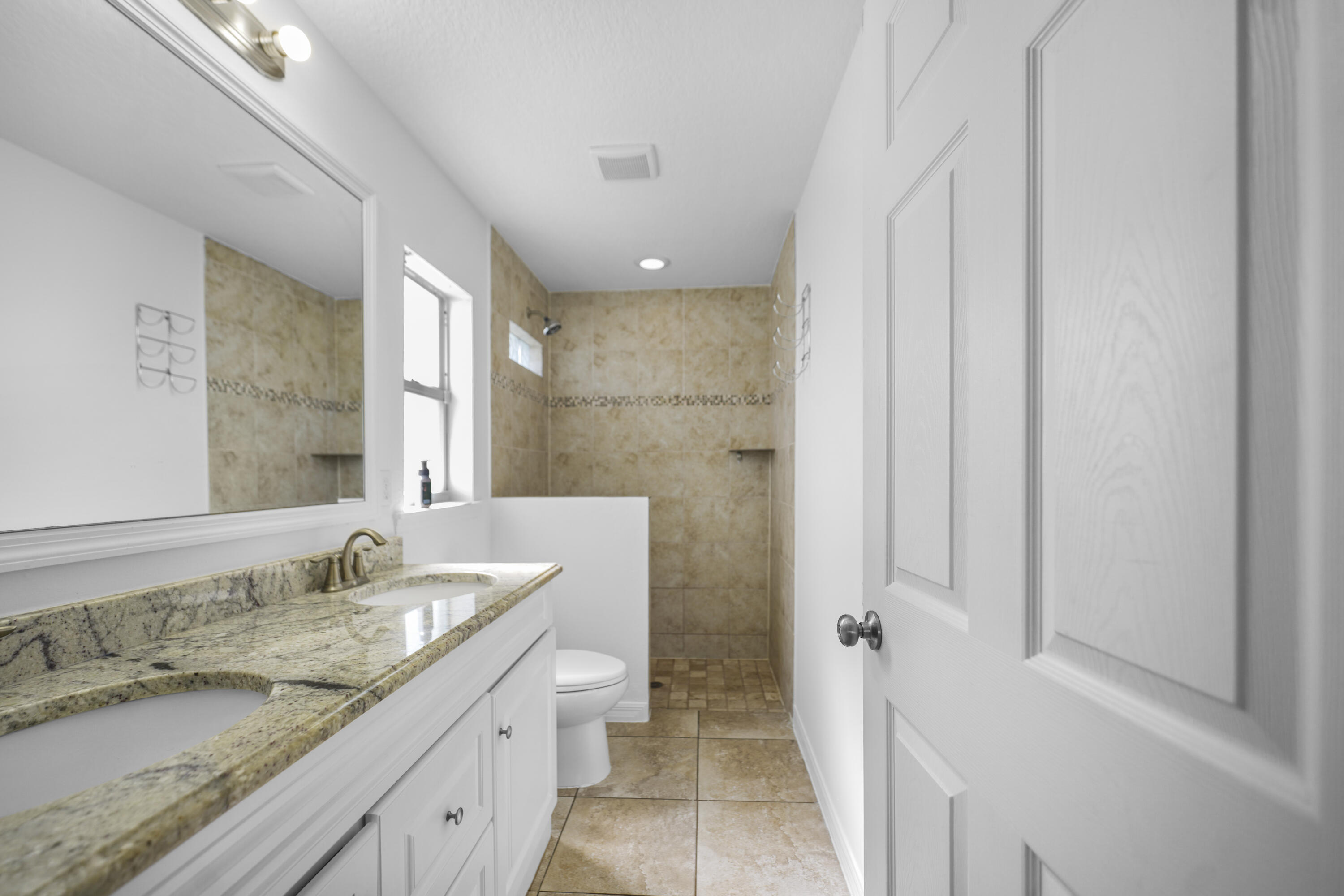 3199 Southeast Lime Tree Trail Stuart, FL 34997 - Photo 17 of 34 a bathroom with a granite countertop sink and a mirror