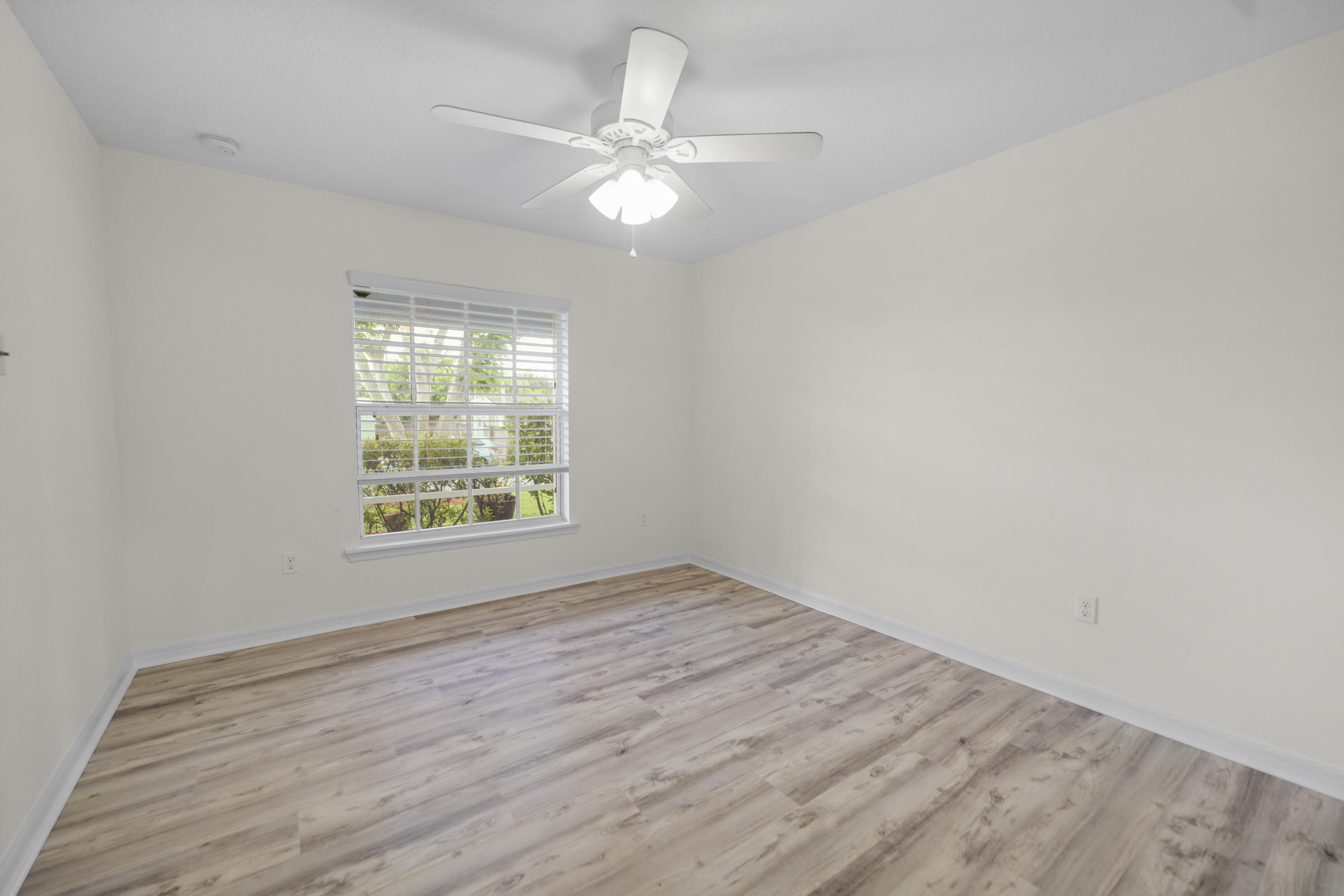 3199 Southeast Lime Tree Trail Stuart, FL 34997 - Photo 18 of 34 wooden floor in an empty room with a window