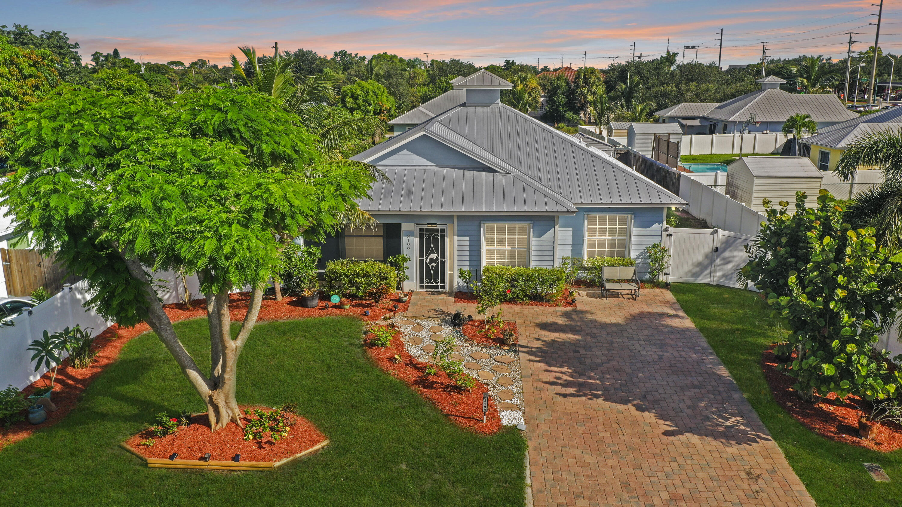 3199 Southeast Lime Tree Trail Stuart, FL 34997 - Photo 2 of 34 a front view of a house with a yard table and chairs
