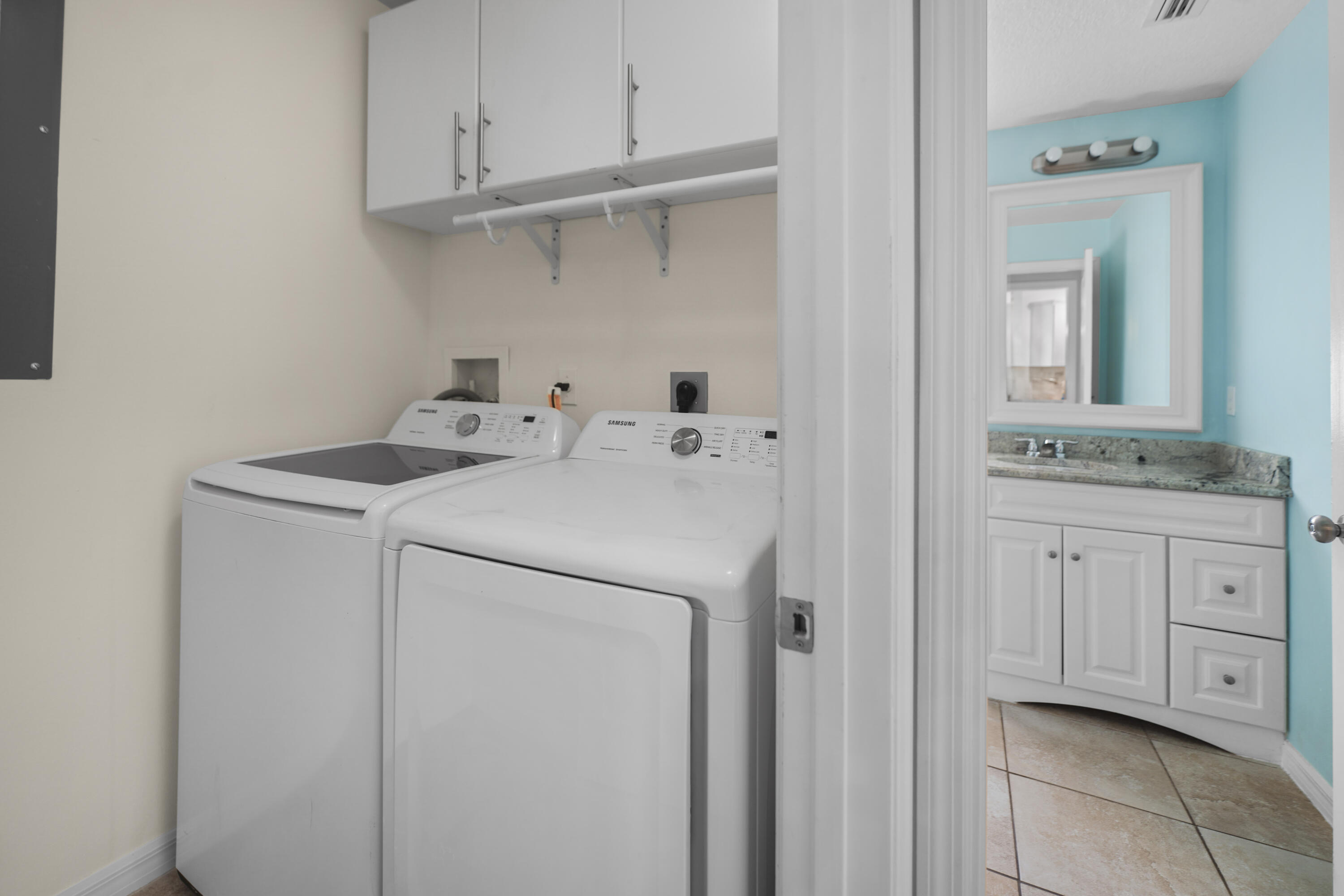 3199 Southeast Lime Tree Trail Stuart, FL 34997 - Photo 24 of 34 a utility room with cabinets washer and dryer
