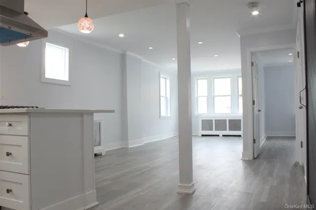 a view of a hallway with wooden floor and closet