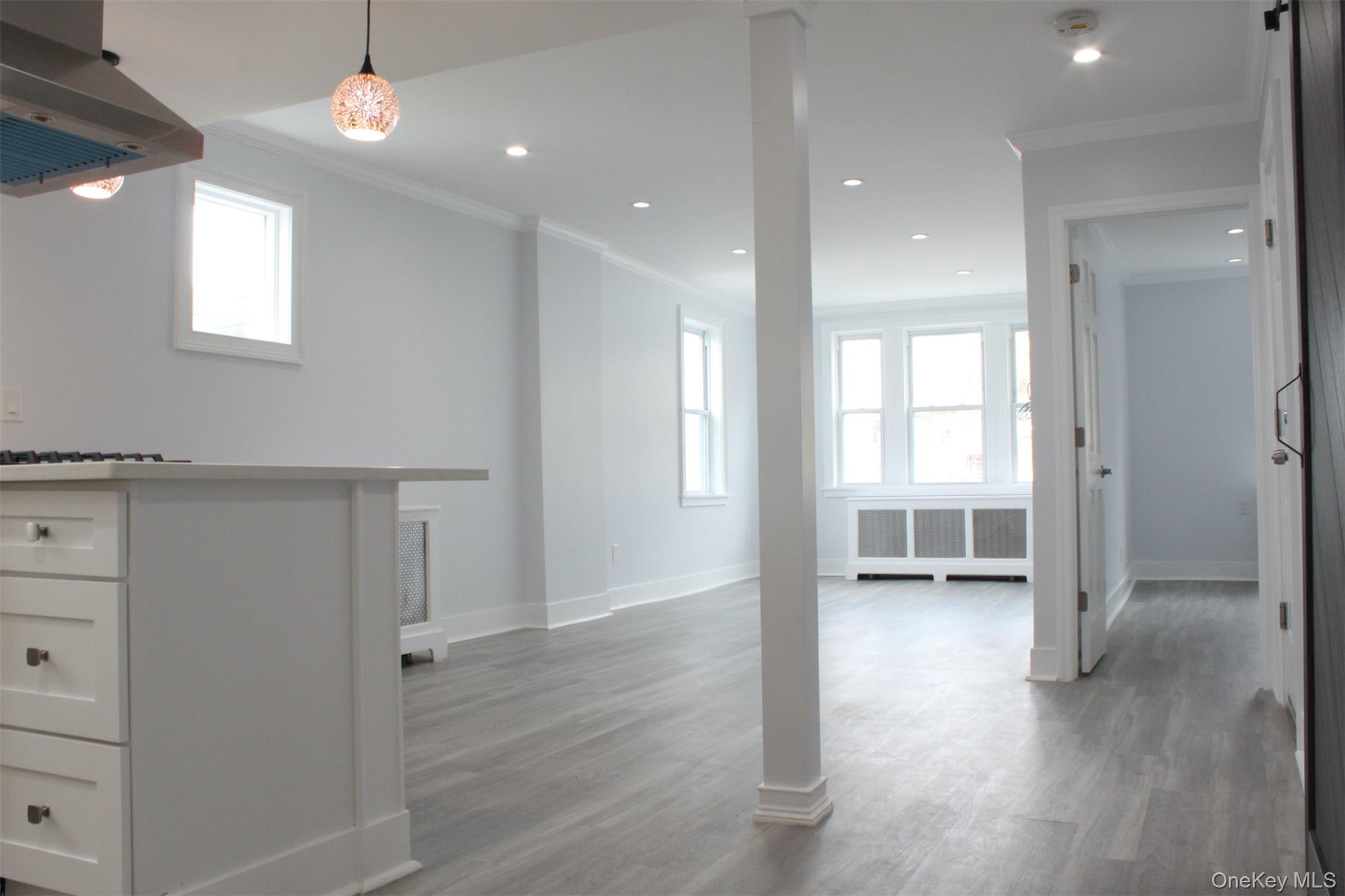 a view of a hallway with wooden floor and closet