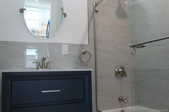 a bathroom with a sink a mirror a vanity and a shower