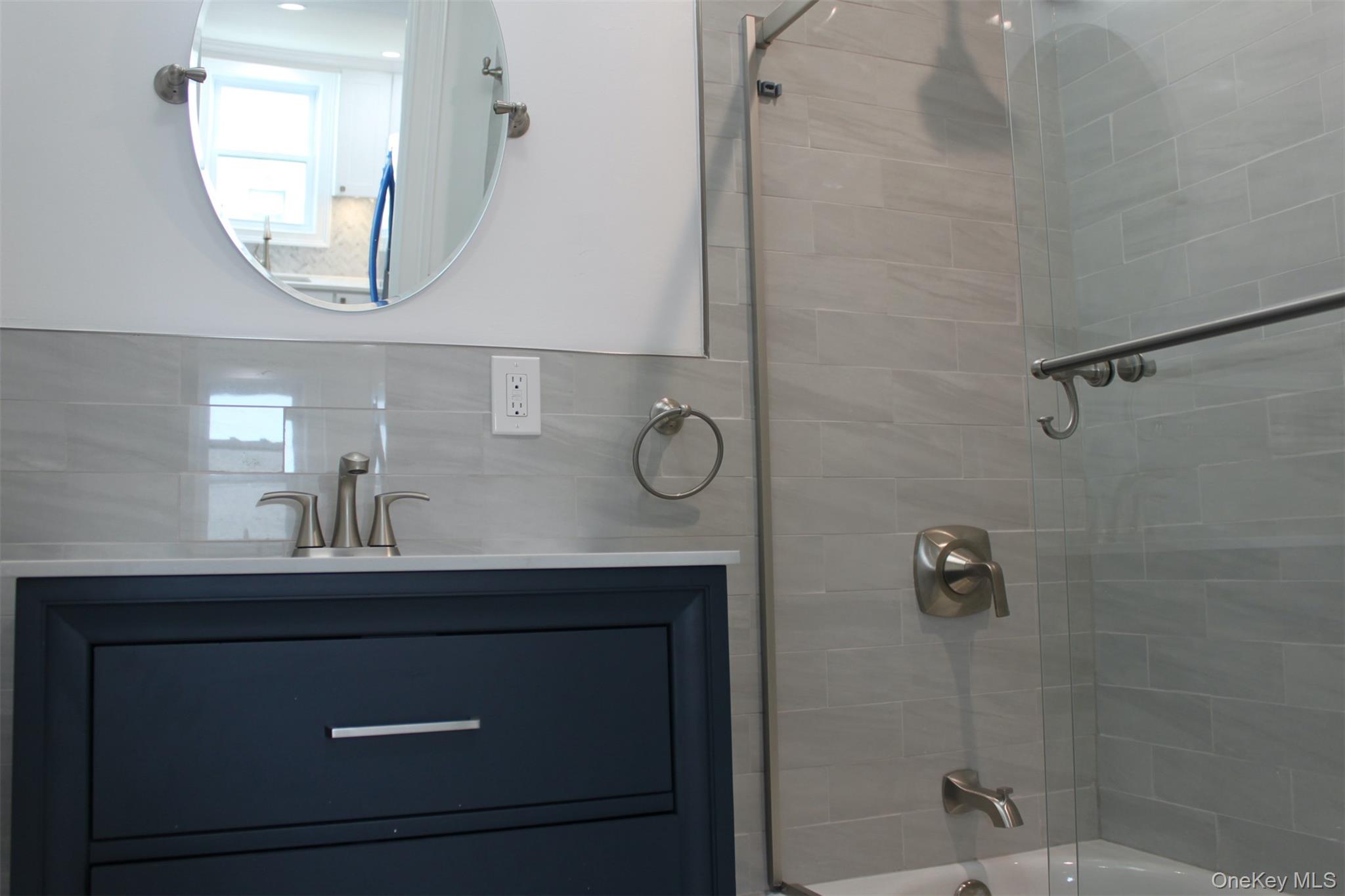 451 Warburton Avenue, Unit 3 Hastings-on-Hudson, NY 10706 - Photo 11 of 16 a bathroom with a sink a mirror a vanity and a shower