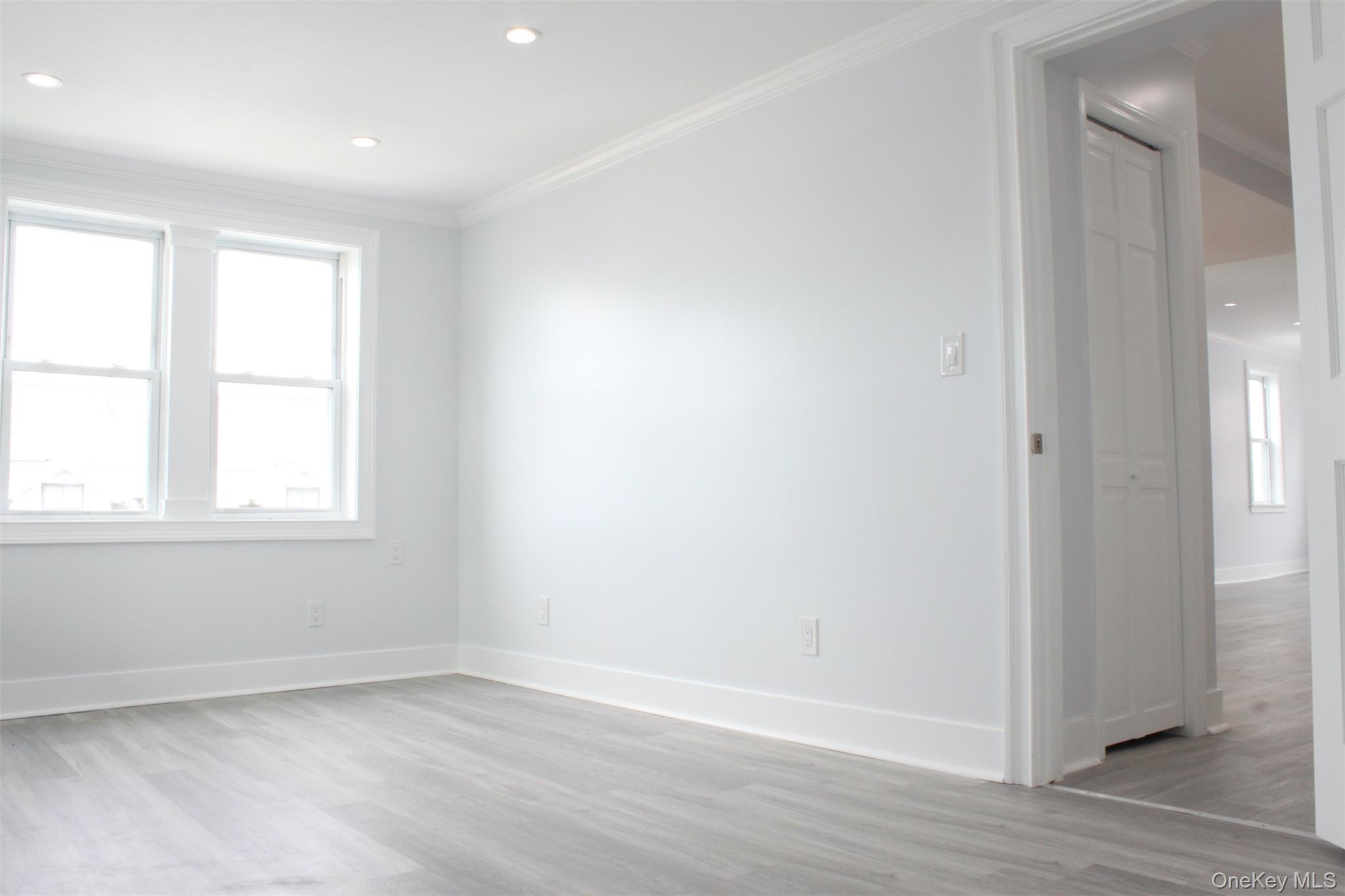 451 Warburton Avenue, Unit 3 Hastings-on-Hudson, NY 10706 - Photo 8 of 16 an empty room with wooden floor and windows