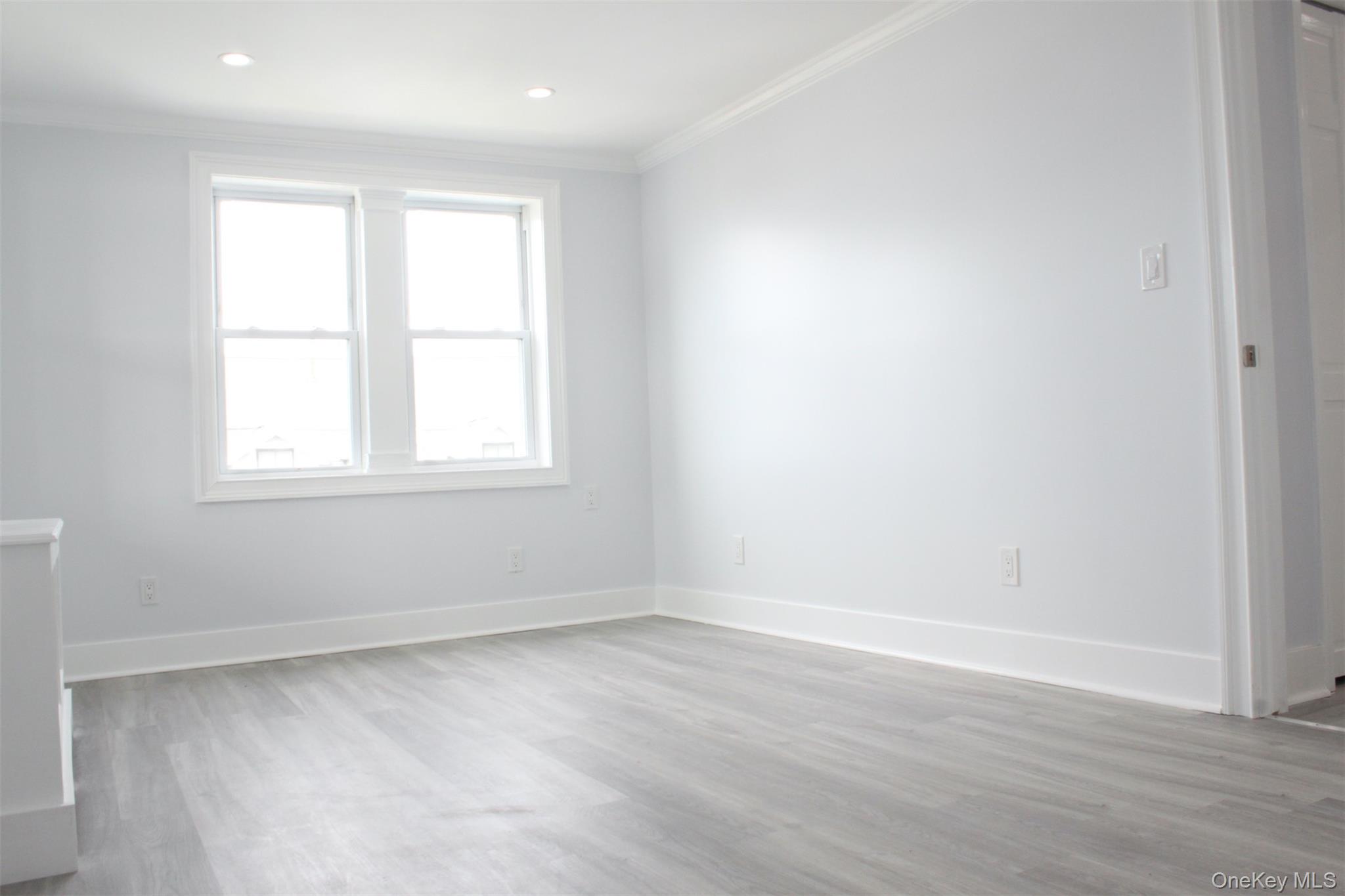 451 Warburton Avenue, Unit 3 Hastings-on-Hudson, NY 10706 - Photo 9 of 16 an empty room with wooden floor and windows