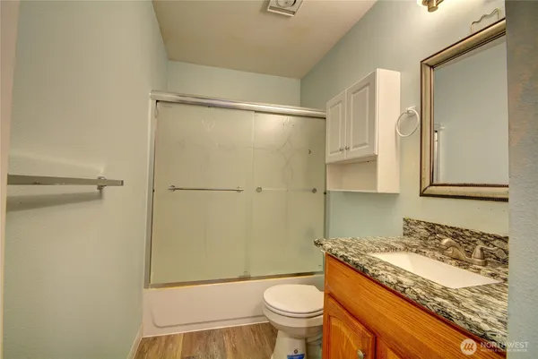 a bathroom with a granite countertop sink toilet and shower