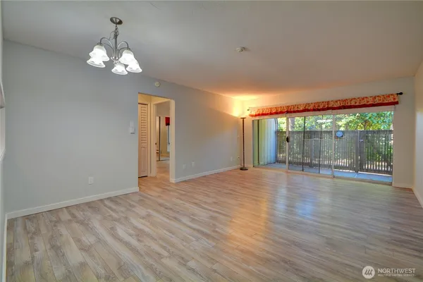 a view of a room with wooden floor and a large window