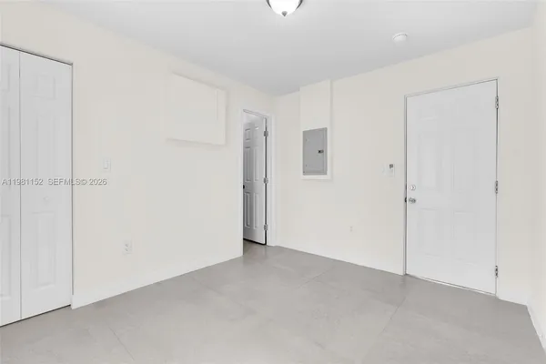 an empty room with fireplace and cabinet