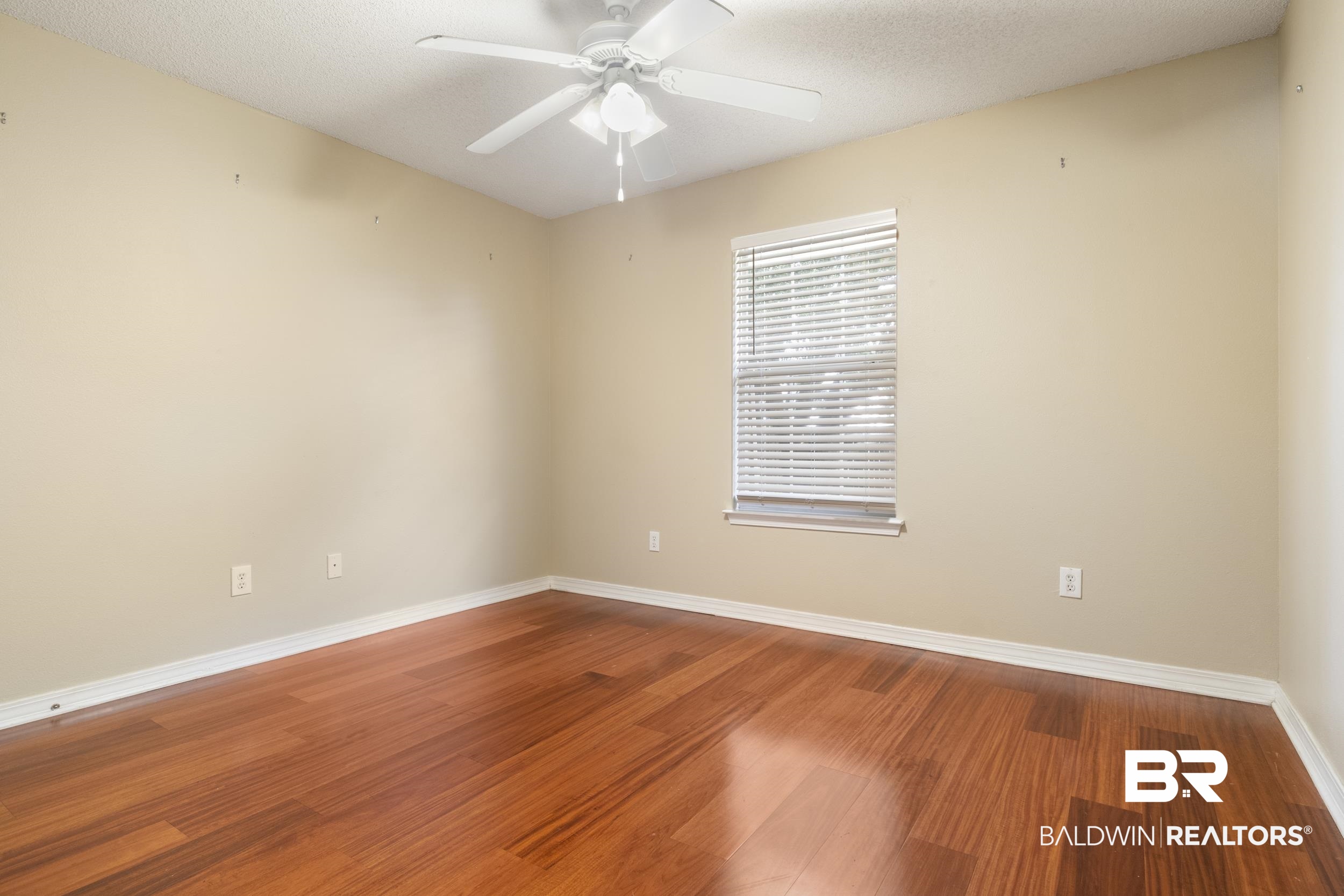 9610 Watkins Drive Fairhope, AL 36532 - Photo 11 of 26 Unfurnished room with hardwood / wood-style flooring, a textured ceiling, and ceiling fan