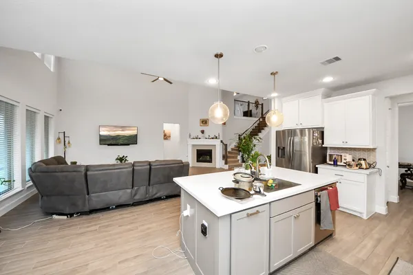 a large kitchen with sink a counter space and living room view