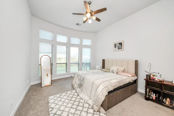 a bedroom with a large bed and a chandelier