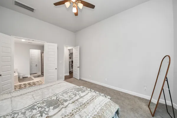 a en suite spacious bathroom with a tub double vanity window and mirror