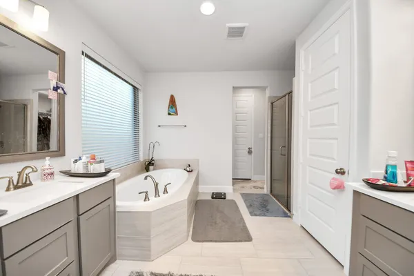 a bathroom with a bathtub sink and mirror