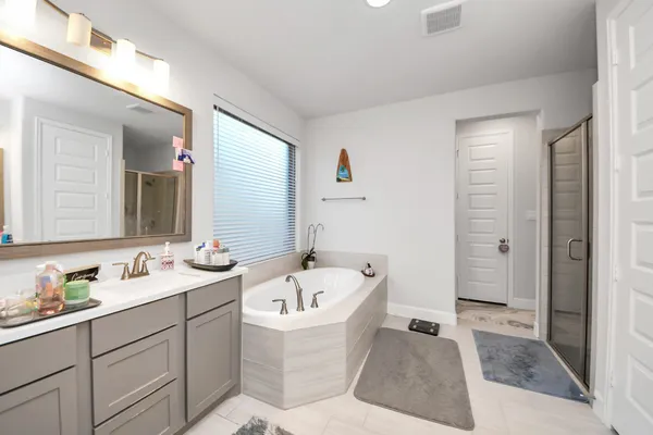a spacious bathroom with a bathtub sink and mirror