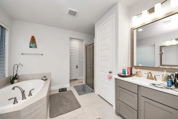 a bathroom with a tub sink and mirror
