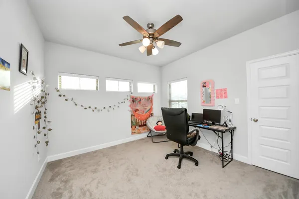 a view of a workspace with furniture and a window