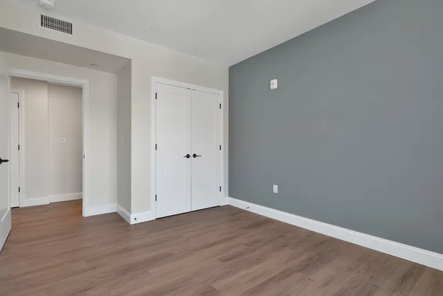 a view of an empty room with wooden floor