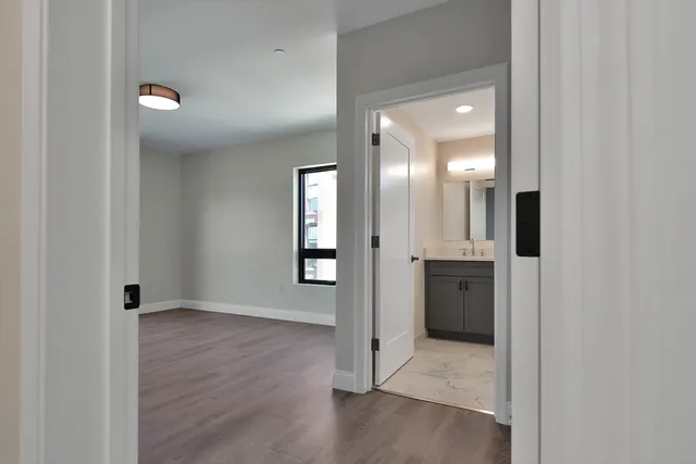 an empty room with wooden floor and mirror