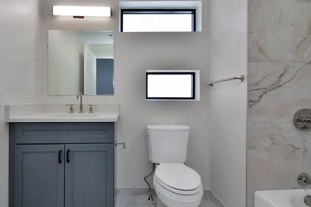 a bathroom with a toilet sink and mirror